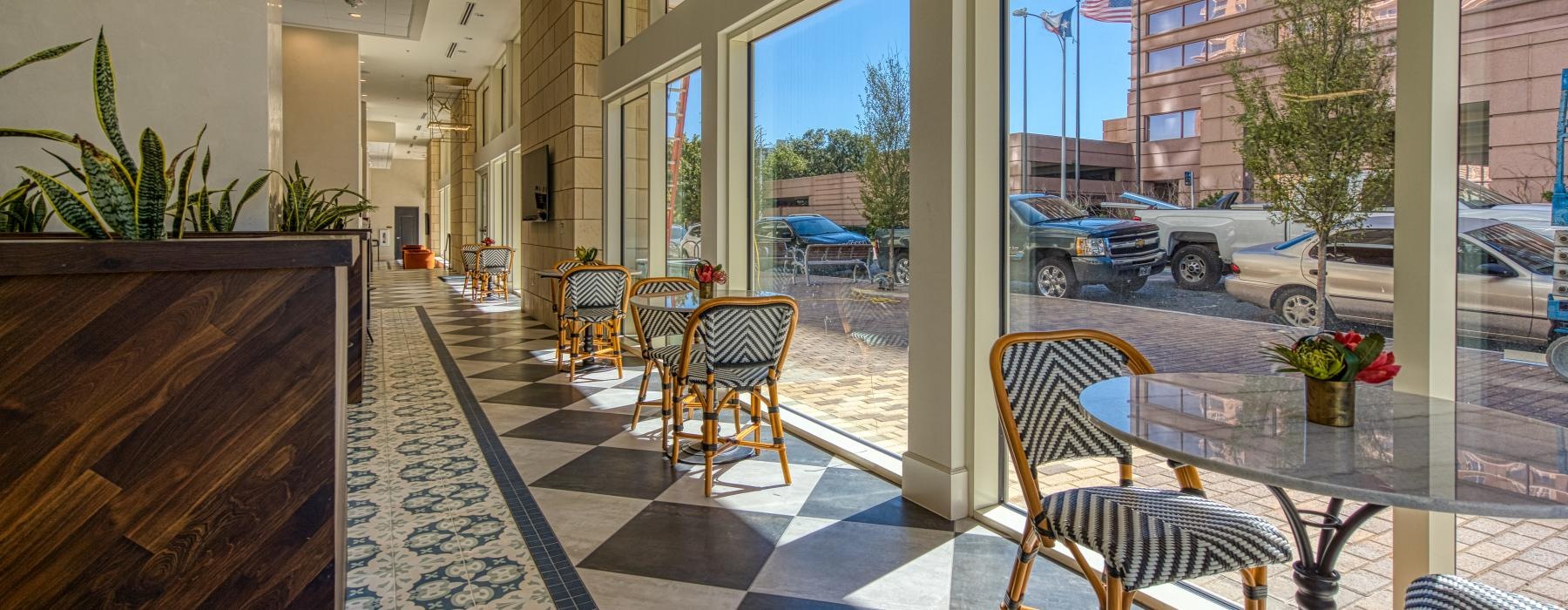 a room with a table chairs and cars outside